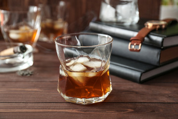 Glass of cold whiskey on wooden table
