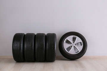 Obraz na płótnie Canvas Car tires near light wall
