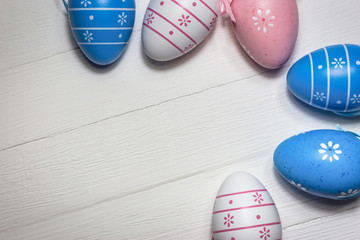 Colorful Easter eggs on white wooden background