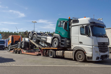 Zugmaschinentransport mit neuen Zugmaschienen auf einem Parkplatz