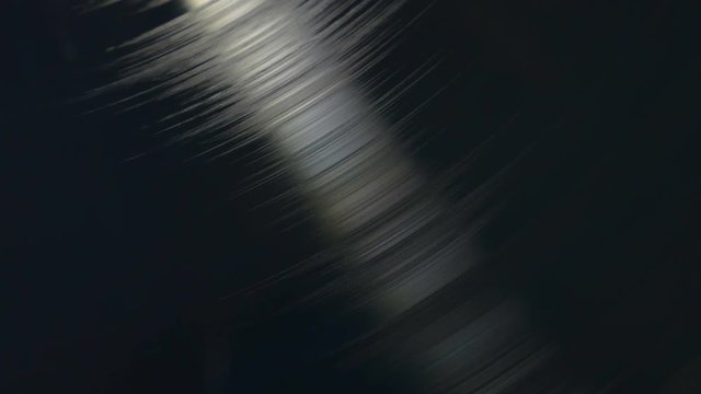 Spinning professional black vinyl record, top view in closeup, 4K footage