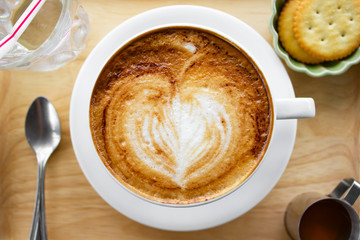 Cup of cappuccino coffee with heart shape latte art on old wood table Background, Latte coffee on old wooden Background table