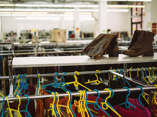 Young woman is browsing a rail of clothes at mall store