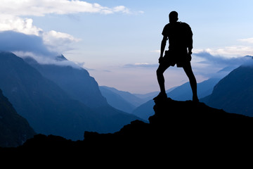 Man on successful hiking, silhouette in mountains