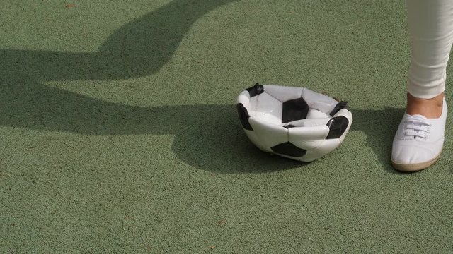 Girl push broken soccer ball by foot then jump on deflated ball in rage. After stop and kick it away, slow motion shot. Loose in game or unsuccessful team concept