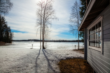 Winter landscape - House stand by the lake on a Sunny day
