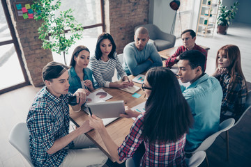 Serious pensive thoughtful professionals in casual checkered clothes shirts having appointment training  project document using laptop netbook computer sitting at table top view