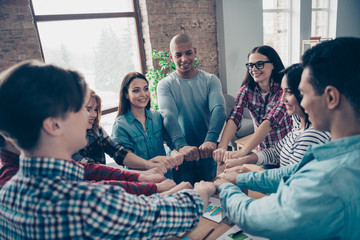 Partners partnership positive friends place fists together to make circle show unity strength success growth dressed in casual wear in cozy boardroom office