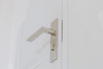 Metallic knob (locksmith) on white door horizontal.