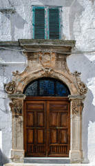 Facade of old building with magnificent door in the old town of Ostuni, La Citta Bianca