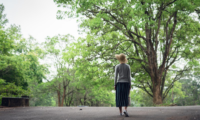 woman take a walk on the way under the trees