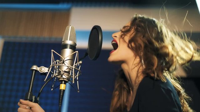 Beautiful young singer who recorded a song in a professional recording studio. Female vocal