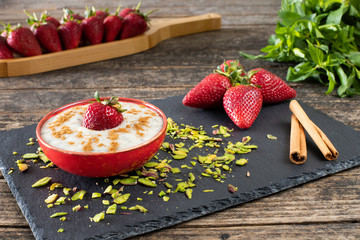 Strawberries in a bowl on the wooden rustic table