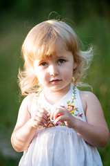 two years old caucasian girl in white dress closeup portrait