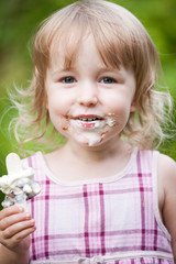 two years old blonde white girl portrait face soiled with ice cream