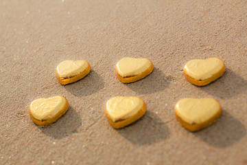 Chocolate color Lovely golden heart on the beach. Background is a natural in real place, creative Valentine's Day Concept, tropical style background made in Phuket, Thailand.