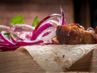 grilled barbecue meat served on a wooden Board with fresh vegetables and spices