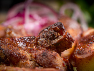 grilled barbecue meat served on a wooden Board with fresh vegetables and spices