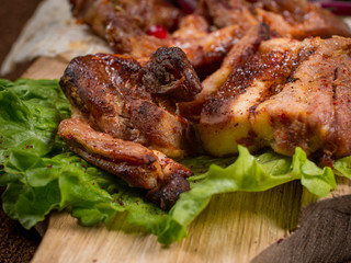 grilled barbecue meat served on a wooden Board with fresh vegetables and spices