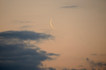 Dawn with storm clouds. In The dim light a moon is outlined in its last phase in a waning quarter. Vitoria-Gasteiz (Alava) Basque Country, Spain