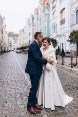 Naklejka premium Romantic walk of the groom and the bride through the streets of the city.