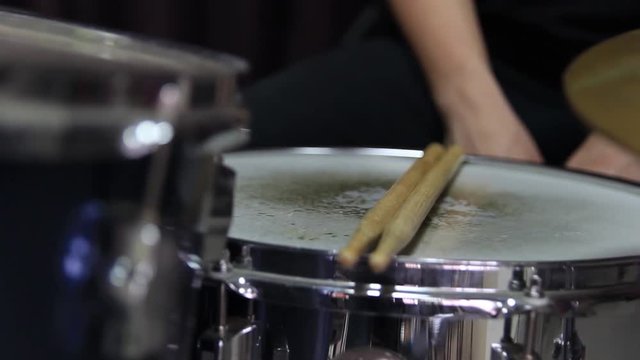 Drumsticks are placed on the snare drum. Close-up