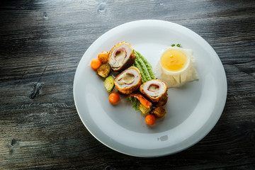 delicious dissected chicken Kiev cutlets with grilled vegetables and sauce