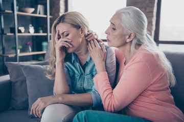 Close up photo two beautiful she her ladies granddaughter tell speak say share difficulties divorce husband desperate break up end finish hide face granny calm down sit couch divan sofa house indoors