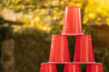 Plastic red solo drinking cups for beer pong or drinking games with green background on a white...