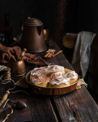 Homemade cinnamon roll buns in vintage copper round pan on wooden rustic table 