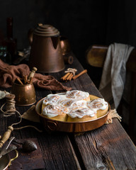 Homemade cinnamon roll buns in vintage copper round pan on wooden rustic table 