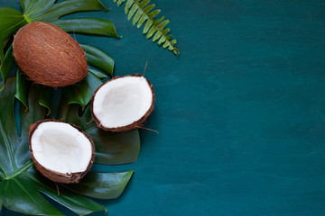 Obraz na płótnie Canvas Coconut with tropical leaves on the wooden dark background frame. Copy space