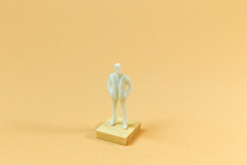  white  figure miniature on orange pastel for business content.