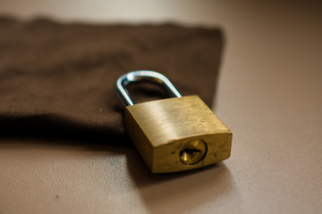 classic padlock closed, vintage-looking style, with a brown cloth behind it