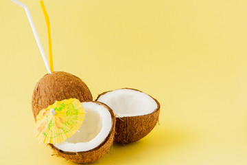 Fresh Coconut cocktail with a straws on yellow background, copy space