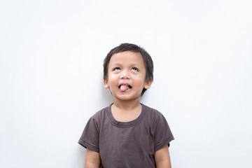 Portrait of a toddler boy making funny face and sticking out his tongue on white background
