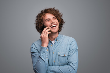Obraz na płótnie Canvas Cheerful male speaking on smartphone