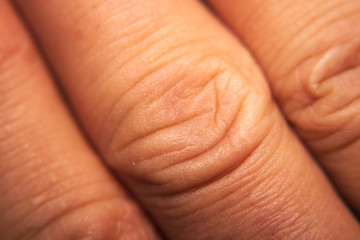 Finger knukles with wrinkles close up.