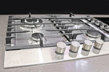 New modern gas stove with four burners for the kitchen, stainless steel surface, cast iron grates