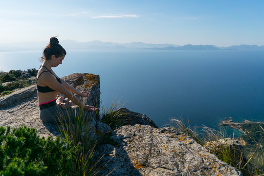 Mujer joven haciendo Yoga en la monta&ntilde;a