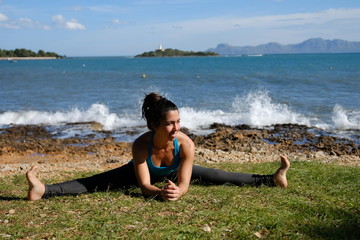 Mujer joven haciendo Yoga en la playa