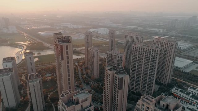 Aerial drone shot over residential apartment buildings on sunset. Aerial shot over community apartment complex in China.
