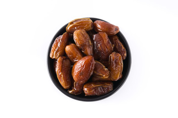 Dates in black bowl isolated on white background. Top view