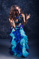 Young attractive girl in a blue suit dancing belly dance.