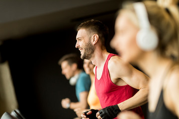 Fototapeta na wymiar young people running on treadmills in modern gym