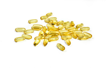 Close up of Gold pile fish oil capsules isolated on white background. Omega 3. Vitamin E. Salmon capsules fish oil view. Supplementary food background.