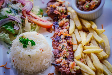 steak served in a restaurant dish with frites and rice