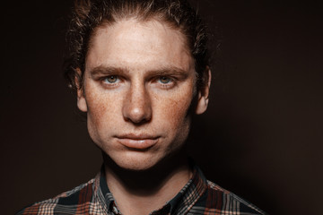 Obraz premium Portrait of a man with drawn hair and freckles, dressed in a checkered shirt