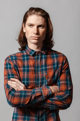 Fototapeta premium Portrait of a man with long hair and freckles, dressed in a checkered shirt
