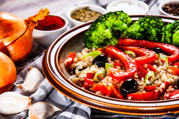 Groats with vegetables on wooden table
